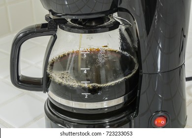 Coffee maker pot filling close up.