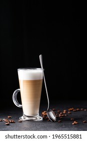 Coffee With Milk, Latte Macchiato In A Glass With A Handle And A Long Spoon On A Black Background, Vertical