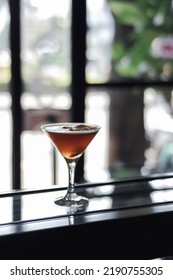 Coffee Mocktail In A Mocktail Glass On A Glass Base With Blurry Highlight Background