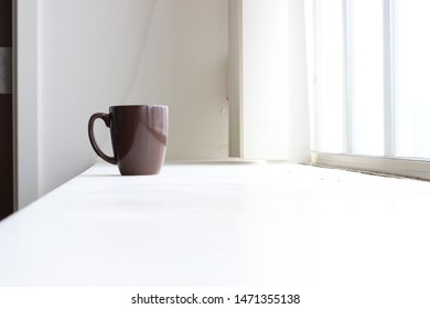 A Coffee Mug Sitting On A Wide Window Ledge