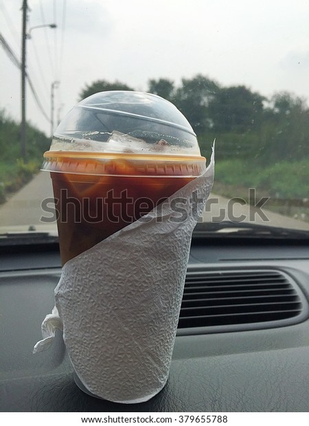 Coffee on front car dashboard\

