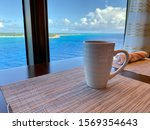 Coffee on a table aboard a cruise ship overlooking the beautiful turquoise waters of the Bahamas.