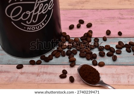 coffee on tea spoon between coffee beans on rustical wooden background