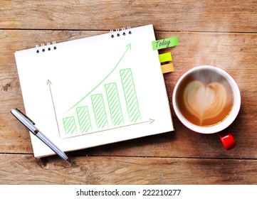 Coffee And Paper With Business Growing Green Graph