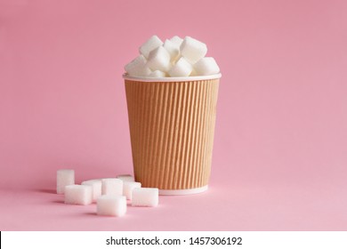 Coffee Paper Cup Full Of Sugar Cubes Standing On Pastel Pink Background, Hidden Sugar In Soda Drinks And Juice Concept, Studio Shot, Energy Source