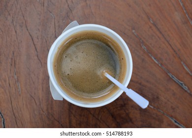 A Coffee In A Paper Cup On Wooden Table. Top View