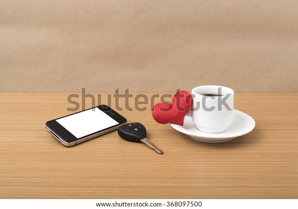 coffee\
phone car key and heart on wood table\
background