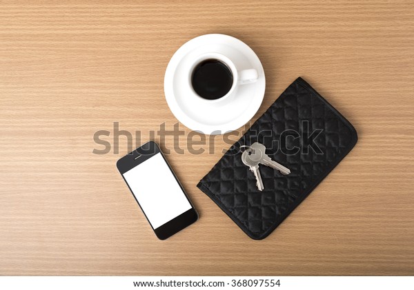 coffee\
phone key and wallet on wood table\
background