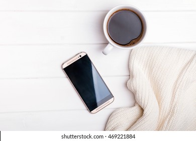 Coffee, Phone And Knitted Sweater On The White Table, Top View