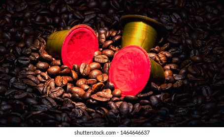 Coffee pods dropped into coffee beans with light focused on the pods