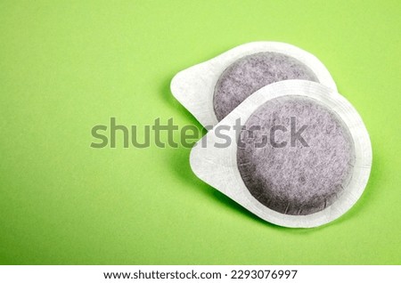 Coffee pods on green background
