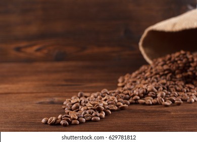 Coffee is poured from a burlap on a wooden background, stilllife