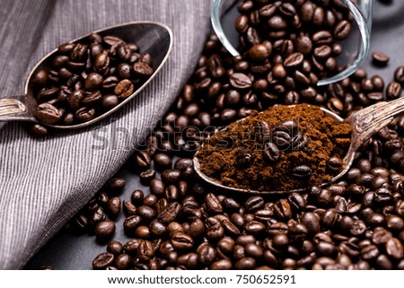 Coffee poured into an ancient antique silverware spoon. Around the spoons scattered coffee beans.
