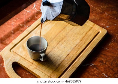 Coffee Is Poured From A Kettle On The Stove Top Down A Cup Of Coffee.(with Smoke).