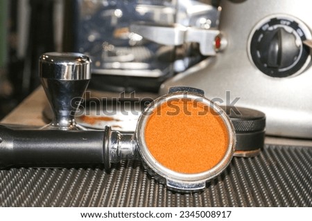 Coffee powder tamper in porta filter before making espresso coffee shots.equipment of espresso machine.put portafilter on bar mat.