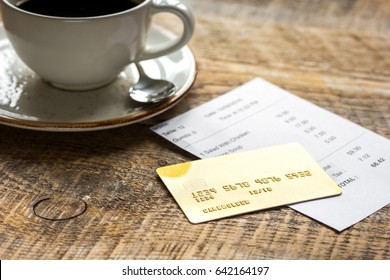 Coffee And Receipt Bill For Payment By Credit Card On Wooden Table Background