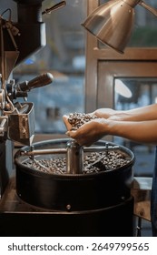 A coffee roastery scene features a pair of hands holding freshly roasted coffee beans under warm lighting