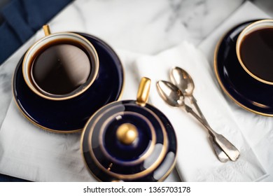 Coffee set up on the table with dark blur porcelain tea or coffee cups and teapot