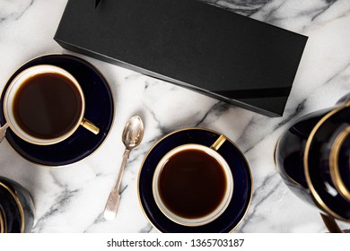 Coffee set up on the table with dark blur porcelain tea or coffee cups and teapot