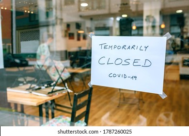 Coffee shop closed by covid-19 with workers picking up and cleaning inside - Shutterstock ID 1787260025
