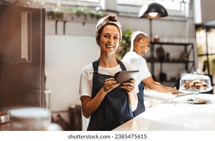 Coffee shop manager efficiently managing her business with the help of a digital tablet. Woman using a touchscreen device to keep track of inventory, update menus, and manage orders with ease.