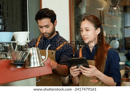 The Coffee shop owner is preparing to make coffee. According to orders that customers order through online applications on tablets. beautiful asian woman and husband Check coffee orders and prepare	
