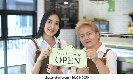 The Coffee Shop Owner Is Raising The Sign For Opening The Service.