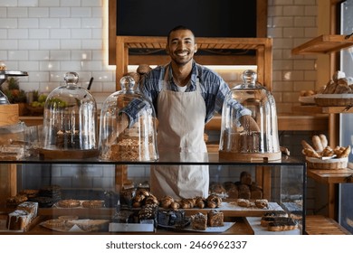 Coffee shop, portrait and happy man waiter in bakery for store welcome, help and friendly hospitality service. Retail, startup and cafe or restaurant server with cake, cookies or counter assistance - Powered by Shutterstock