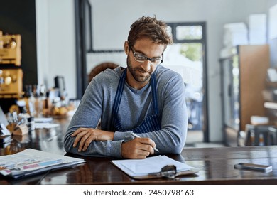 Coffee shop, worker and man with clipboard in restaurant for stock, inventory and price list. Cafe, small business and waiter with documents on table for planning, feedback and review of store - Powered by Shutterstock