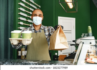 Coffee Shop Worker Wearing Medical Mask While Standing At Counter In Cafeteria