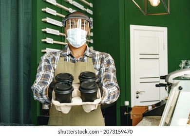 Coffee Shop Worker Wearing Medical Mask While Standing At Counter In Cafeteria