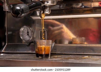 Coffee shots being poured at an expresso machine at a coffee house