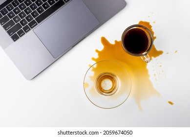 Coffee Spill On A White Working Desk Near Laptop. View From Above