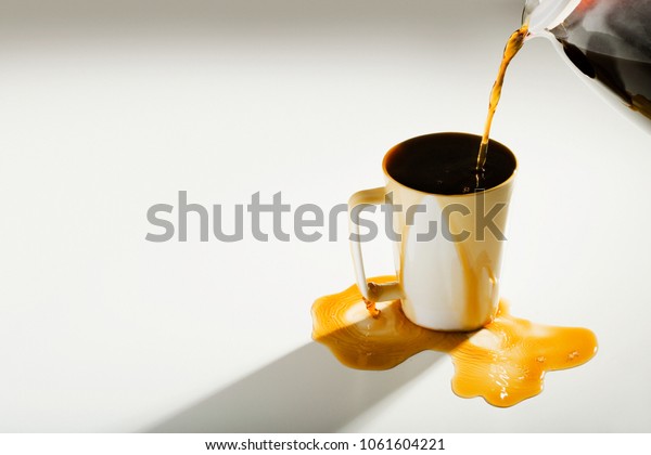Coffee spilling out of a\
cup