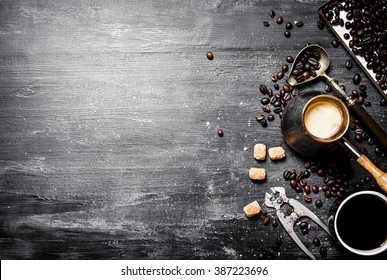coffee style . Brewed coffee pot with sugar and coffee beans around. On a black chalkboard.