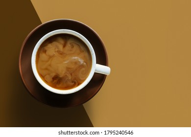 Coffee With Swirl Of Milk Or Cream. Cup Of Morning Drink, Saucer On Double Diagonal Background. Monochrome Horizontal Banner, Poster With Copy Space. Chocolate Brown, Beige Colors. Flat Lay Trend