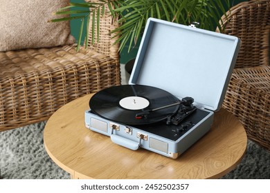 Coffee table with record player and vinyl disk in stylish living room, closeup