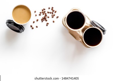 Coffee to take away in paper cups with beans on white table background top view space for text