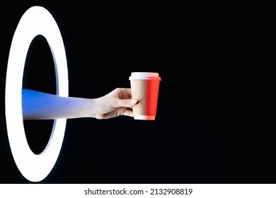 Coffee Takeaway. Beverage Delivery. Energy Drink. Female Hand Offering Logo Mockup Paper Cup In Glowing LED Light Ring Isolated On Dark Night Black Copy Space Background.