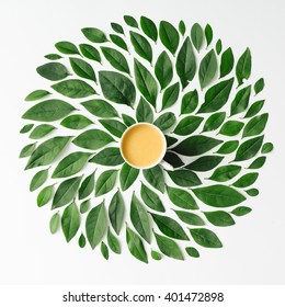 Coffee or tea cup on green leaves background Flat lay.