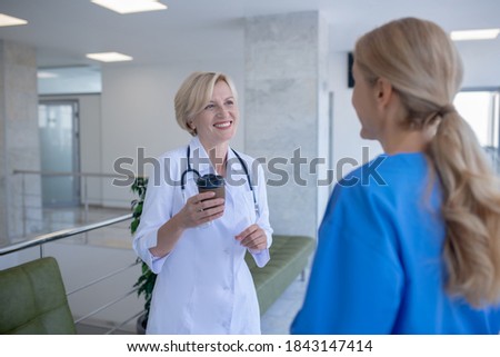 Coffee time. Two female doctors enjoying coffee, having friendly conversation