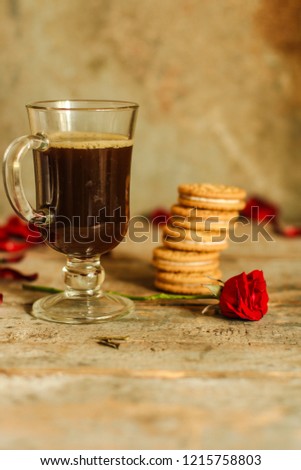 coffee in a transparent cup and roses on the table (brewed tea bag). top view.
