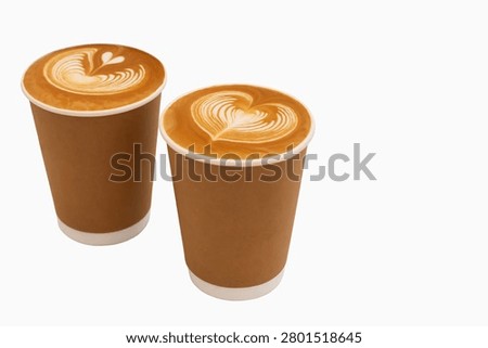 Coffee. Two disposable coffee cups filled with latte art showcasing heart designs on surface, positioned closely together against clean white background with copy space, intricate patterns of foam