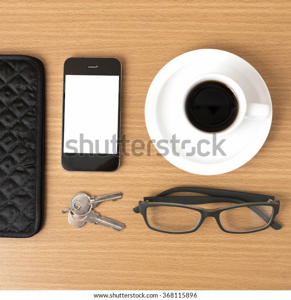 coffee,phone,key,eyeglasses and wallet on wood\
table\
background