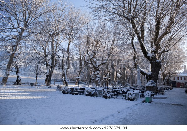coffees shops tables chairs in\
the snow ice in  winter season in Ioannina city Greece  whtie\
color