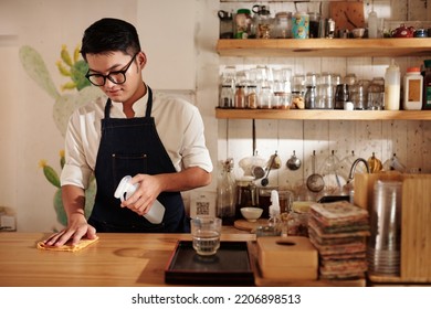 Coffeeshop Barista Wiping Counter With Disinfecting Detergent