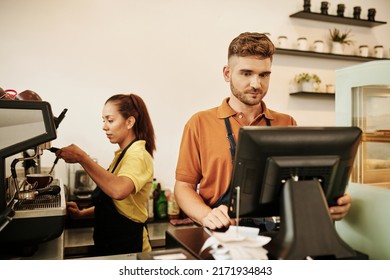 Coffeeshop owner working at cashier desk when b as tostada making coffee - Powered by Shutterstock