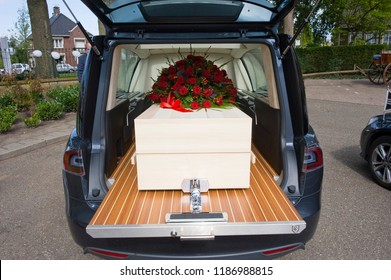 A Coffin With A Flower Arrangement In A Funeral Car