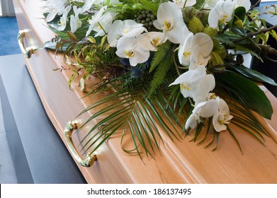 A coffin with a flower arrangement in a morgue - Shutterstock ID 186137495