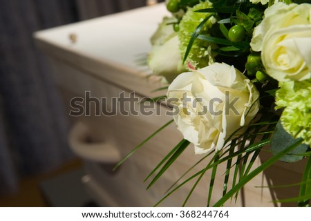 A coffin with a flower arrangement in a morgue